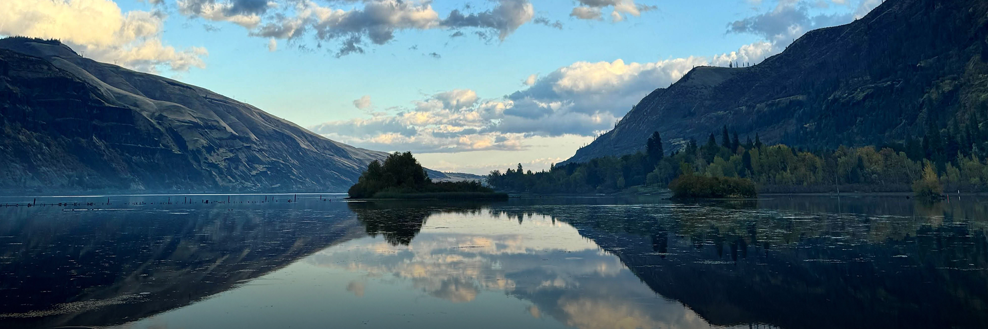 The Columbia River at dawn, with basin mountains and sky mirrored in still water