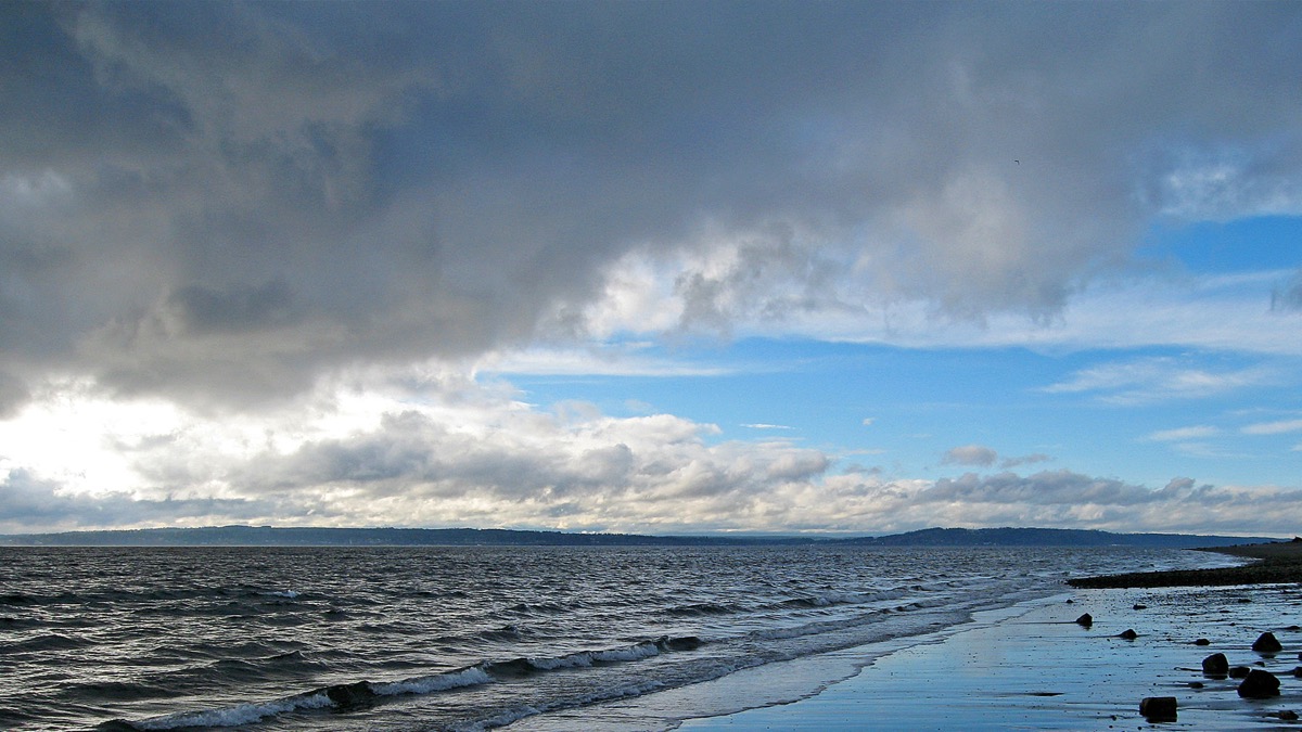 Storm clouds over a Puget Sound beach at low tide